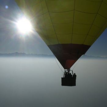 Mongolfiera in volo sopra le nuvole